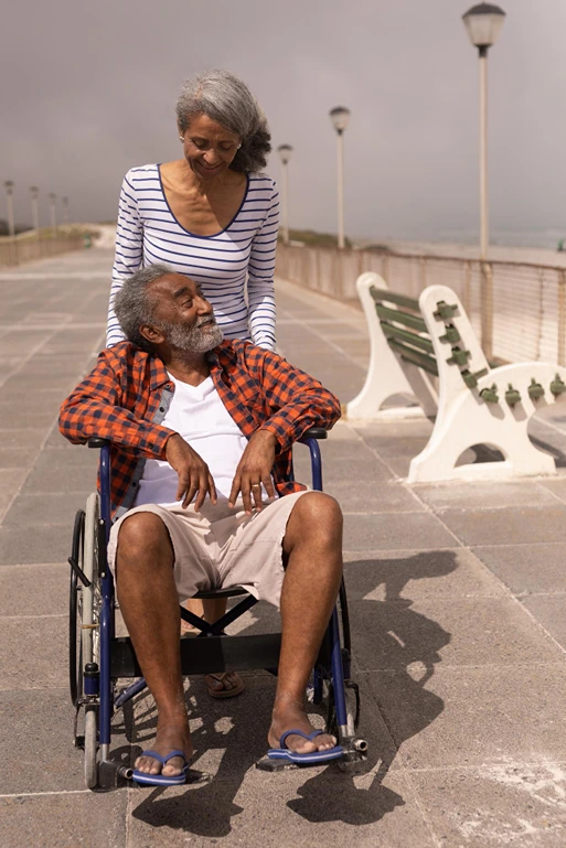 um casal de idosos, um deles está em uma cadeira de rodas enquanto o outro empurra a cadeira. Eles estão atrás de um advogado previdenciário especialista em Benefício de Prestação Continuada (BPC/LOAS) em Franca-SP