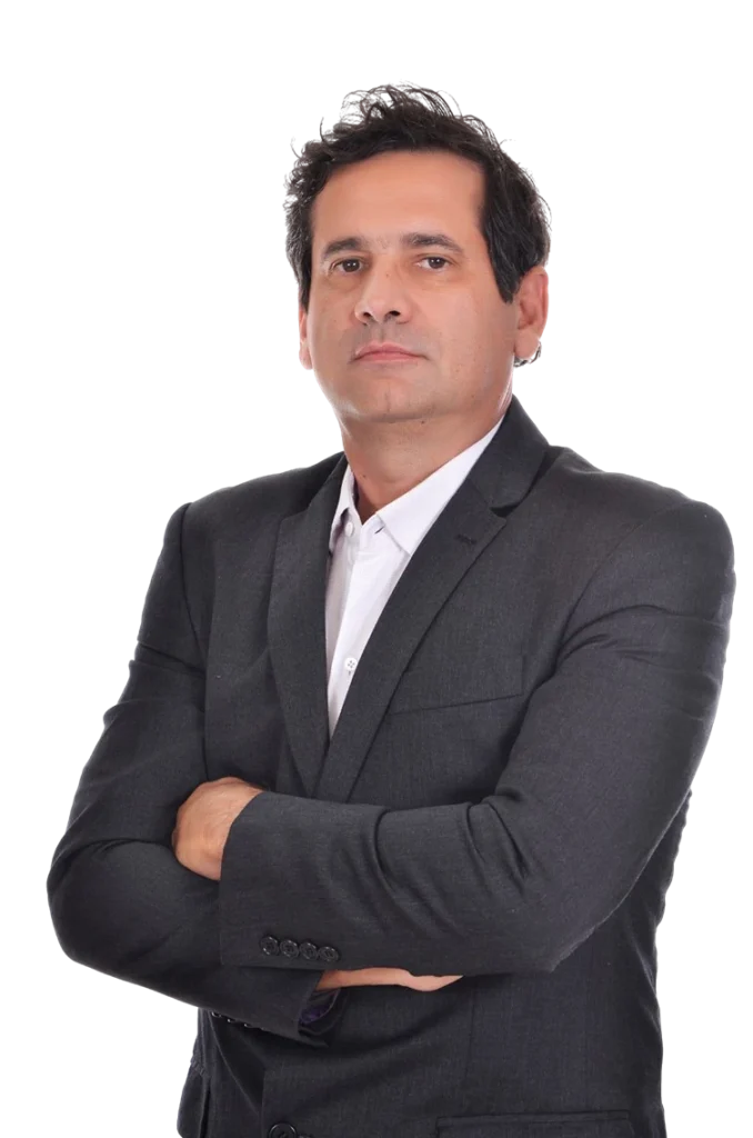 Imagem do Dr Luis Fernando Coli. Ele é um homem de pele branca, olhos castanhos e cabelo castanho curto penteado em um topete para cima. Ele usa um terno acizentado e está de braços cruzados, demonstrando segurança e confiança. Ele é Advogado Sócio e Consultor Previdenciário