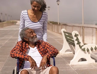 um casal de idosos, um deles está em uma cadeira de rodas enquanto o outro empurra a cadeira. Eles estão atrás de um advogado previdenciário especialista em Benefício de Prestação Continuada (BPC/LOAS) em Franca-SP