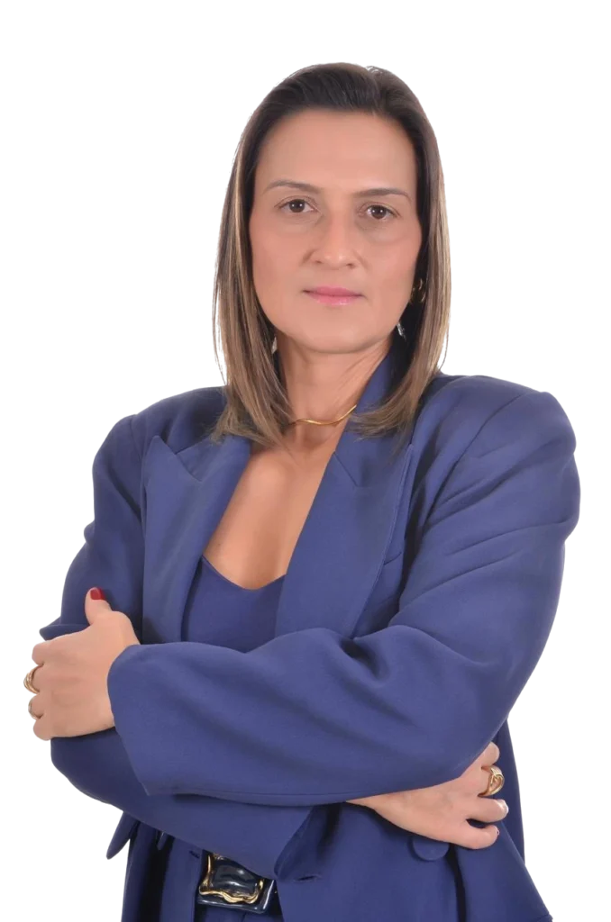 Imagem da Dra Lívia M. Lance. Ela é uma mulher de pele branca, de olhos castanhos, com cabelos loiros que chegam até os seus ombros. Ela está usando um blaser formal azul e está com os braços cruzados, indicando confiança e segurança. Dra Lívia é Sócia e Especialista em Direito Previdenciário e Constitucional